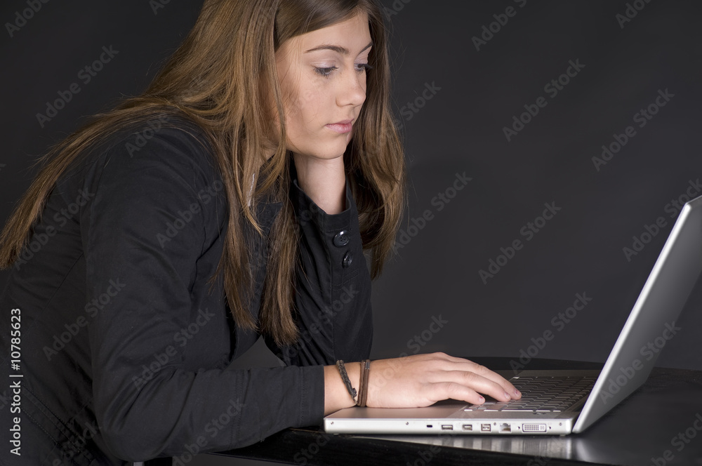 Mädchen mit Laptop auf dunklem Hintergrund Mädchen mit Laptop auf dunklem Hintergrund