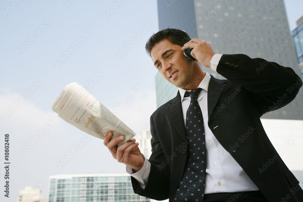 Jeune cadre dynamique au téléphone avec journal en extérieur Stock Photo |  Adobe Stock