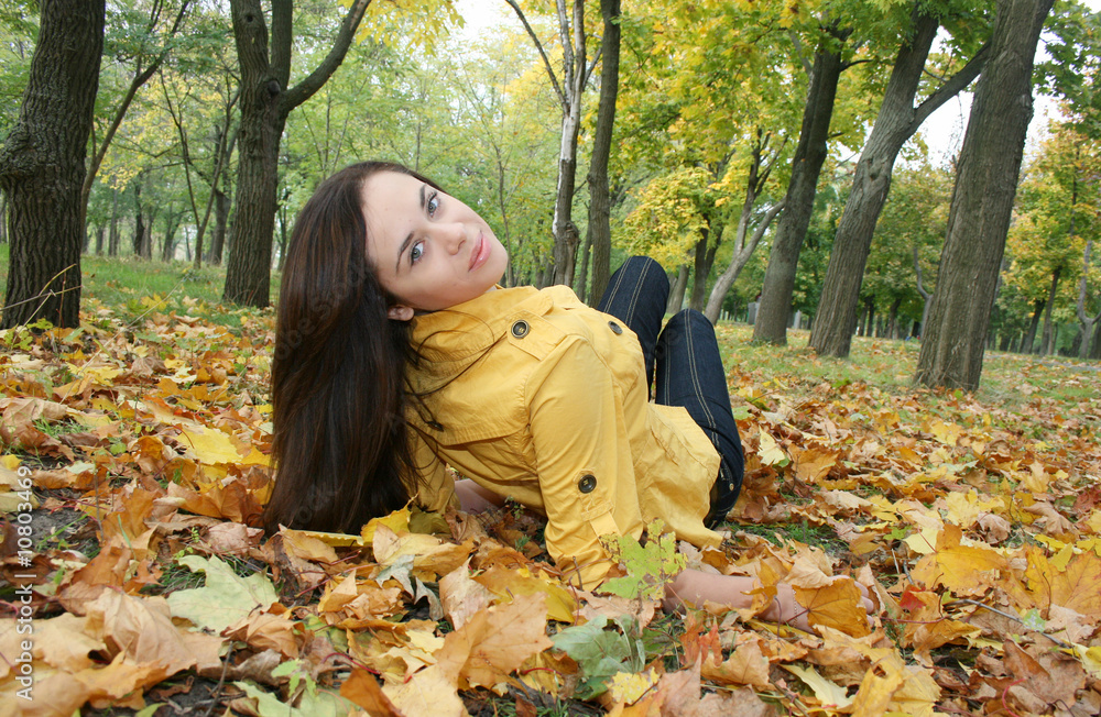 Closeup portrait of a woman lying on ground covered with leaves Closeup portrait of a woman lying on ground covered with leaves