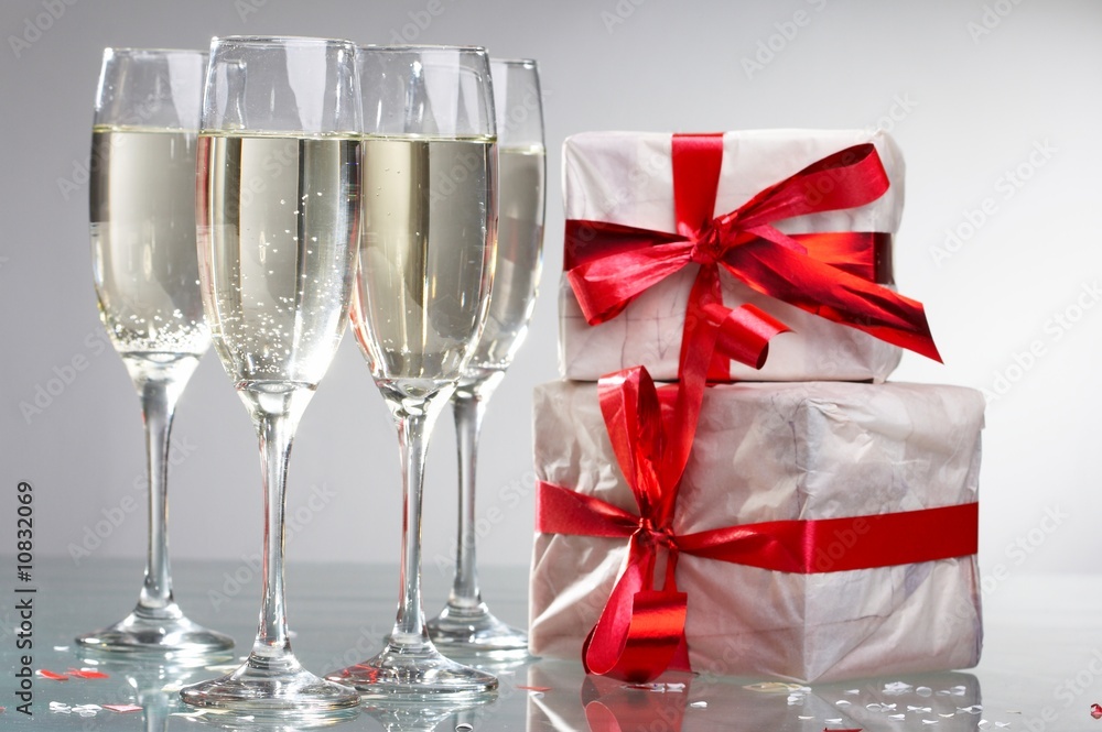 Glasses of champagne, gifts with red tapes and bows Glasses of champagne, gifts with red tapes and bows