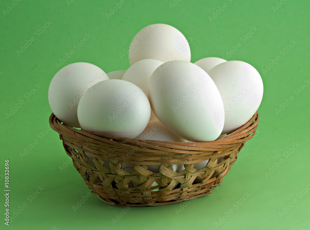 Eggs in basket isolated on green background Eggs in basket isolated on green background