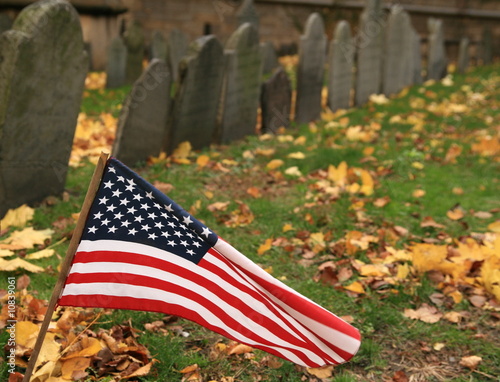 American flag beating in the wind against a graveyard