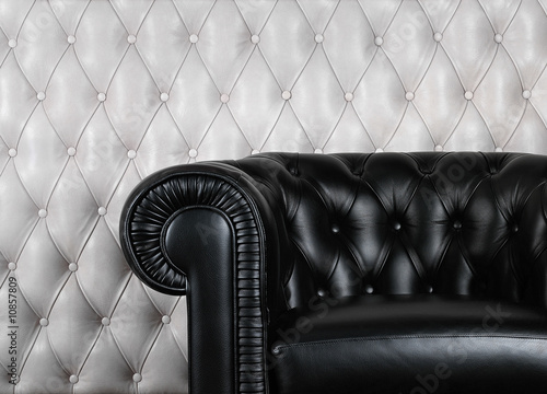 Black leather armchair near white wall