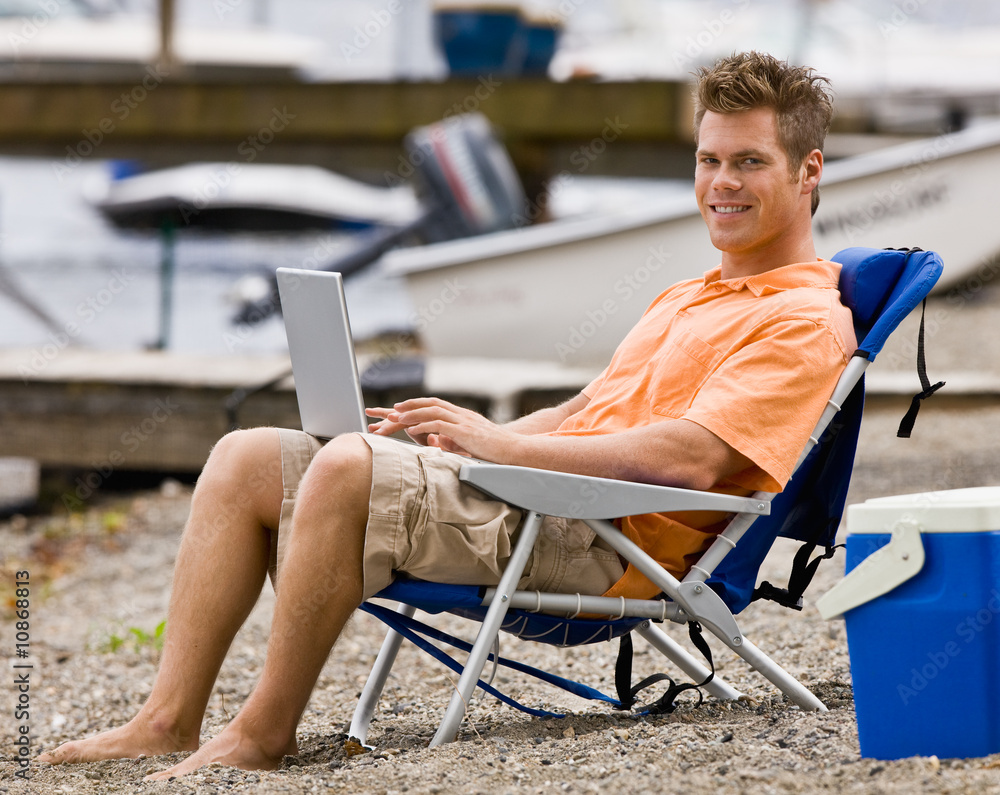 Man using laptop on beach