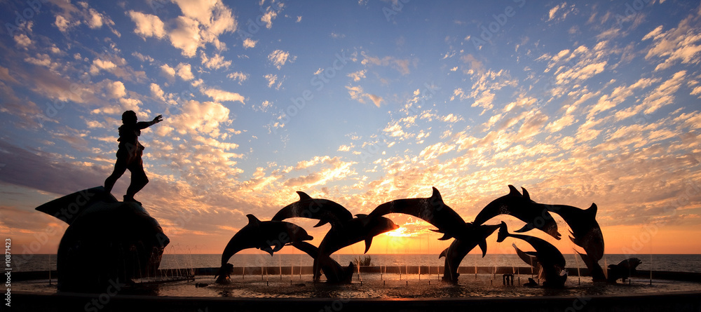 Fototapeta premium Posąg delfina przed zachodem słońca