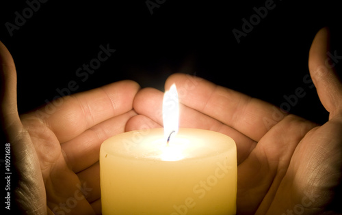 Hands trying to save the candle light