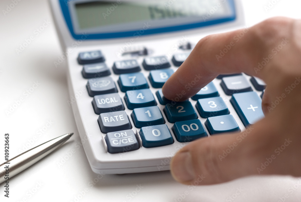 Hand typing on financial calculator Hand typing on financial calculator