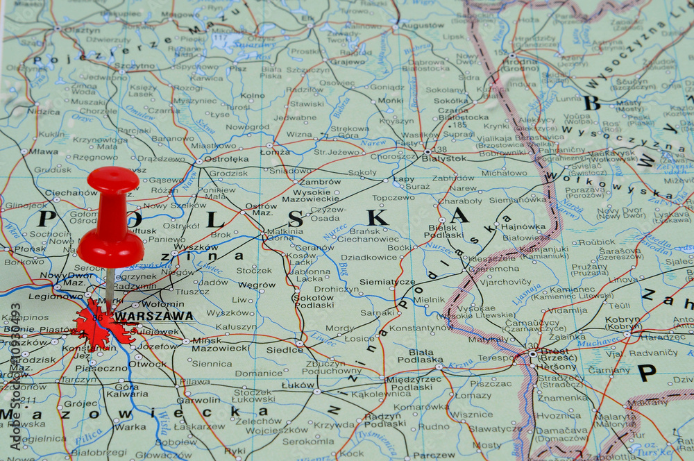 Naklejka premium Pin pointing Warsaw on polish map in atlas