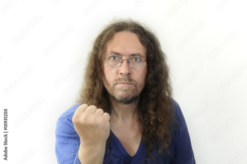 Langhaariger Mann droht mit Faust Langhaariger Mann droht mit Faust