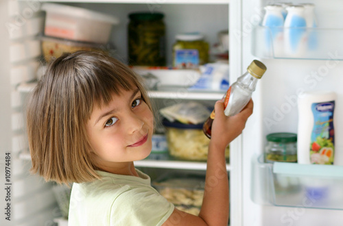 enfant se servant du sirop dans le réfrigérateur