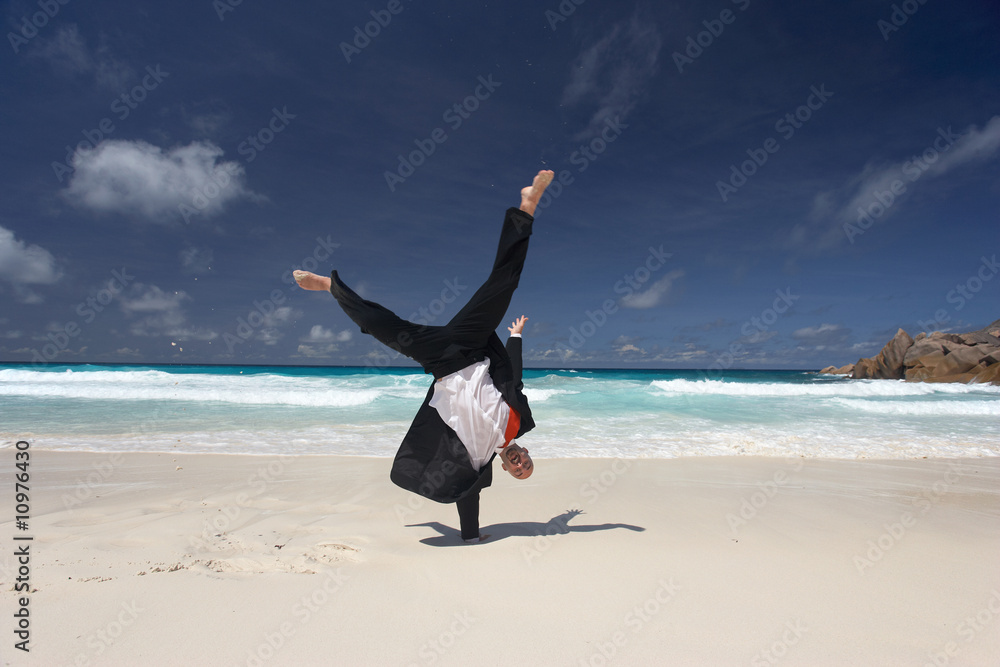 businessman turning wheels on sandy beach