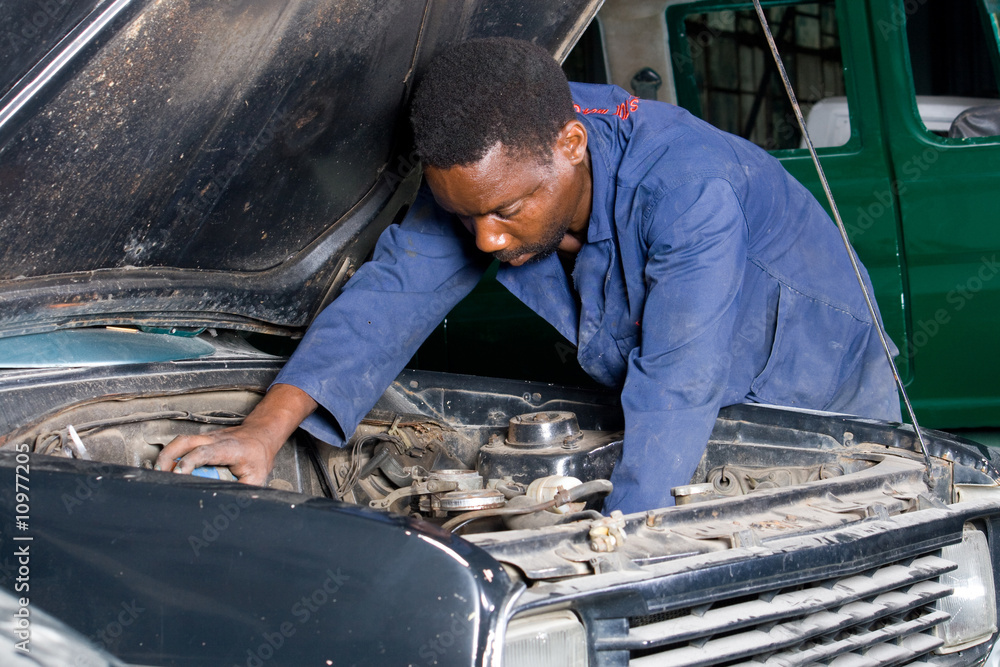 african mechanic working on a car african mechanic working on a car