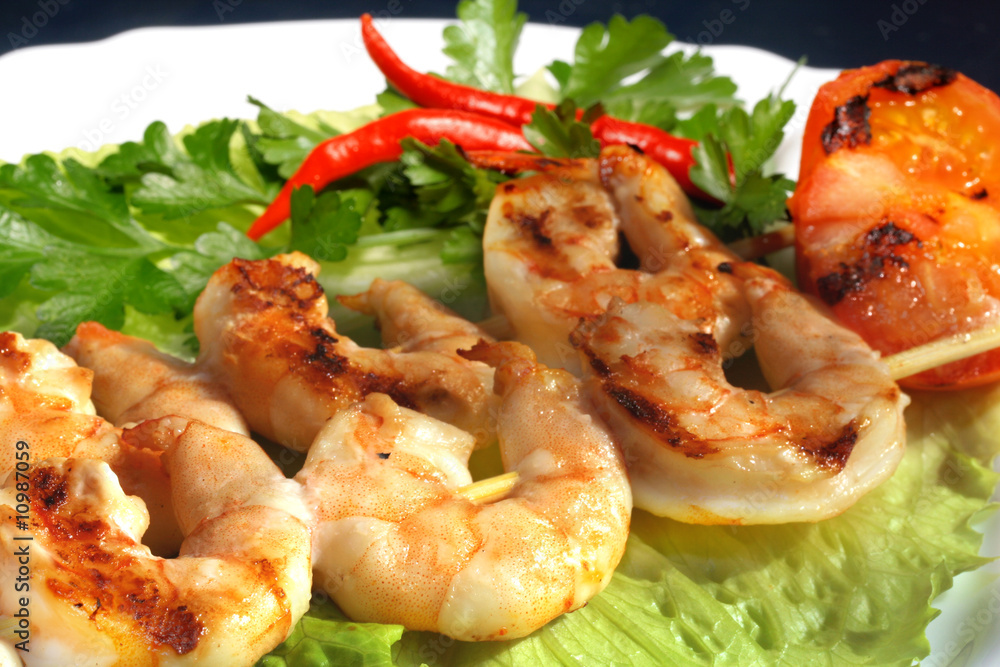 Grilled prawns on bamboo sticks served on lettice Grilled prawns on bamboo sticks served on lettice