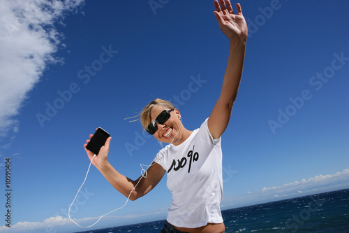 Femme blonde souriante et dynamique avec lecteur mp3 photo