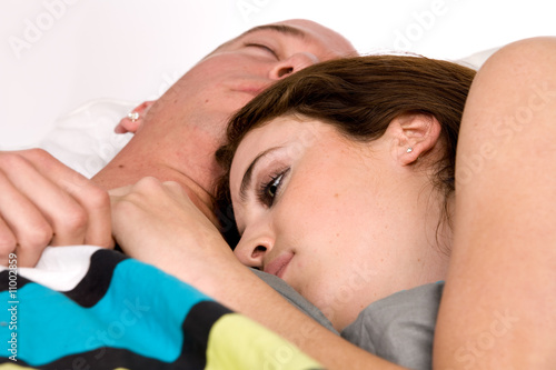 Young couple in bed slowly waking up photo