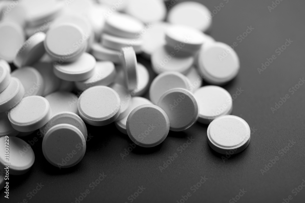 white pills over black background white pills over black background