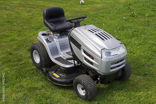 Small silver tractor for cutting lawn.