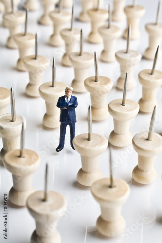 Businessman figurine placed with tacks