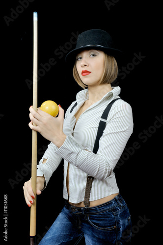 Young beautiful girl in hat with billiard cue and a ball