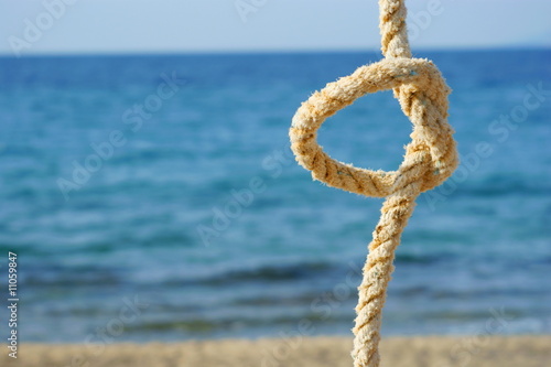 rope with a knot - sea background © Voyagerix