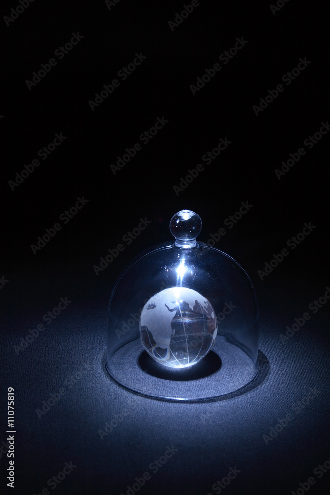 Little globe under glassy cowl on dark background
