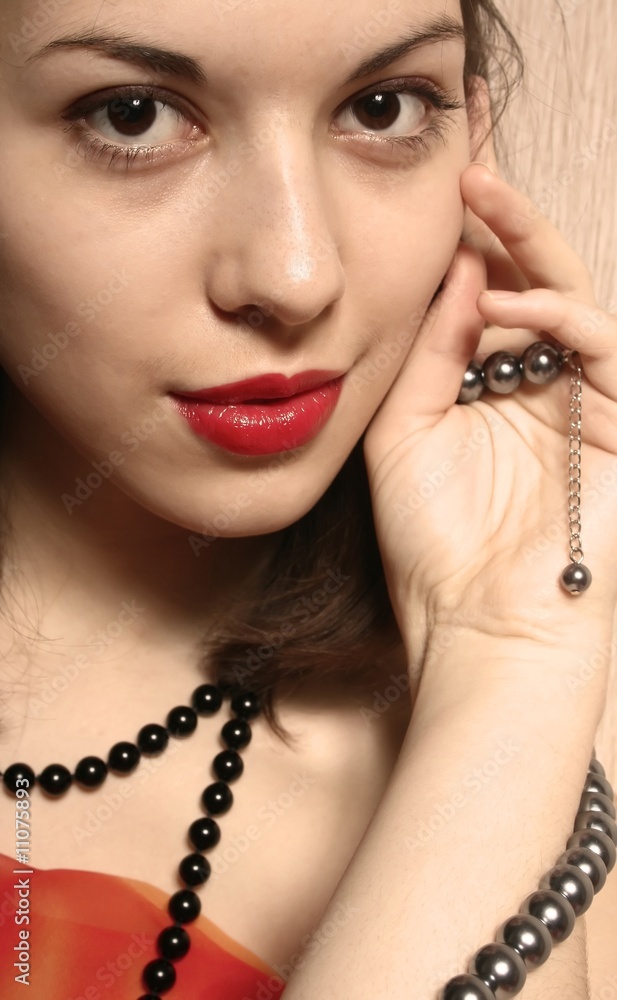 Portrait of the beautiful girl with red lips and a beads.