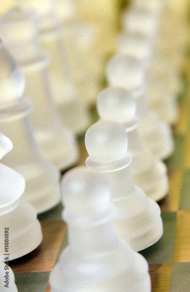 Crystal glass chess figures close up on a glass board. Crystal glass chess figures close up on a glass board.