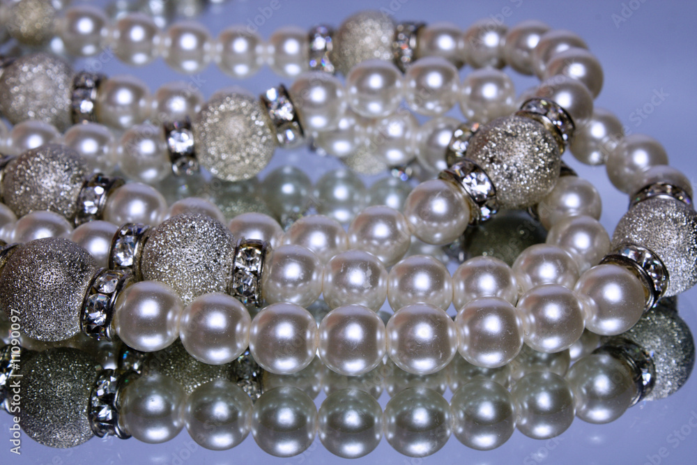 String of artificial pearls on a mirror with reflection String of artificial pearls on a mirror with reflection