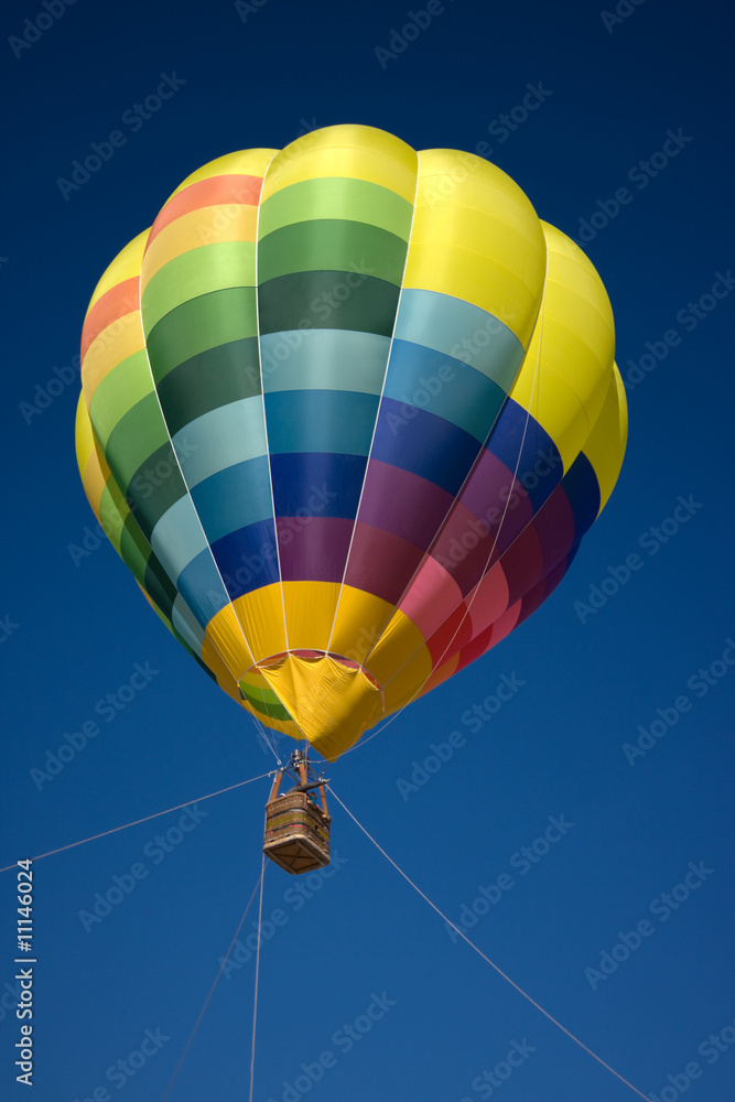 Naklejka premium Globo aerostático sobre el cielo azul