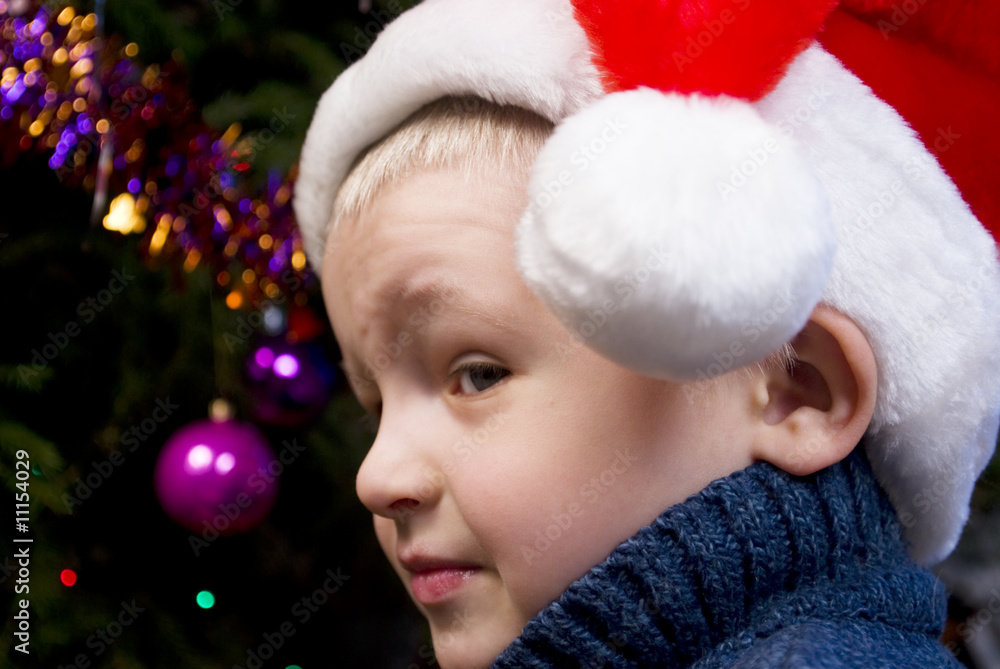 little boy near a cristmas tree little boy near a cristmas tree