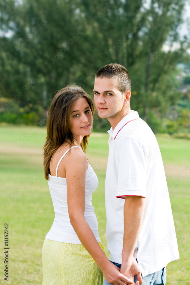 young couple holding hands in the park