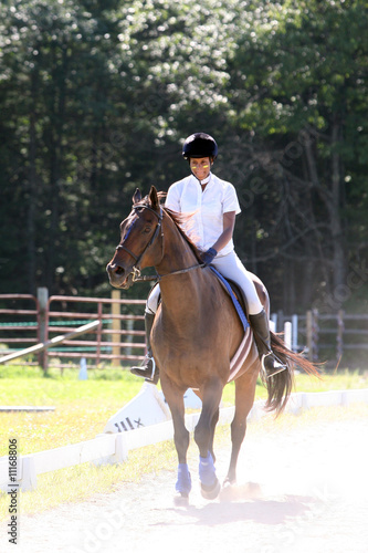 black teenage girl riding her horse in the ring © sparkmom