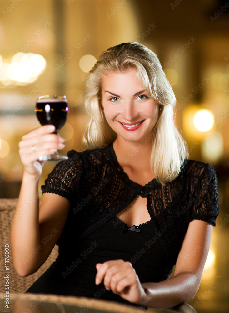 Beautiful young woman drinking red wine in a restaurant