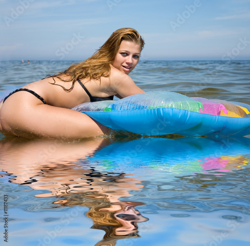 Beautiful girl swimming on mattress photo