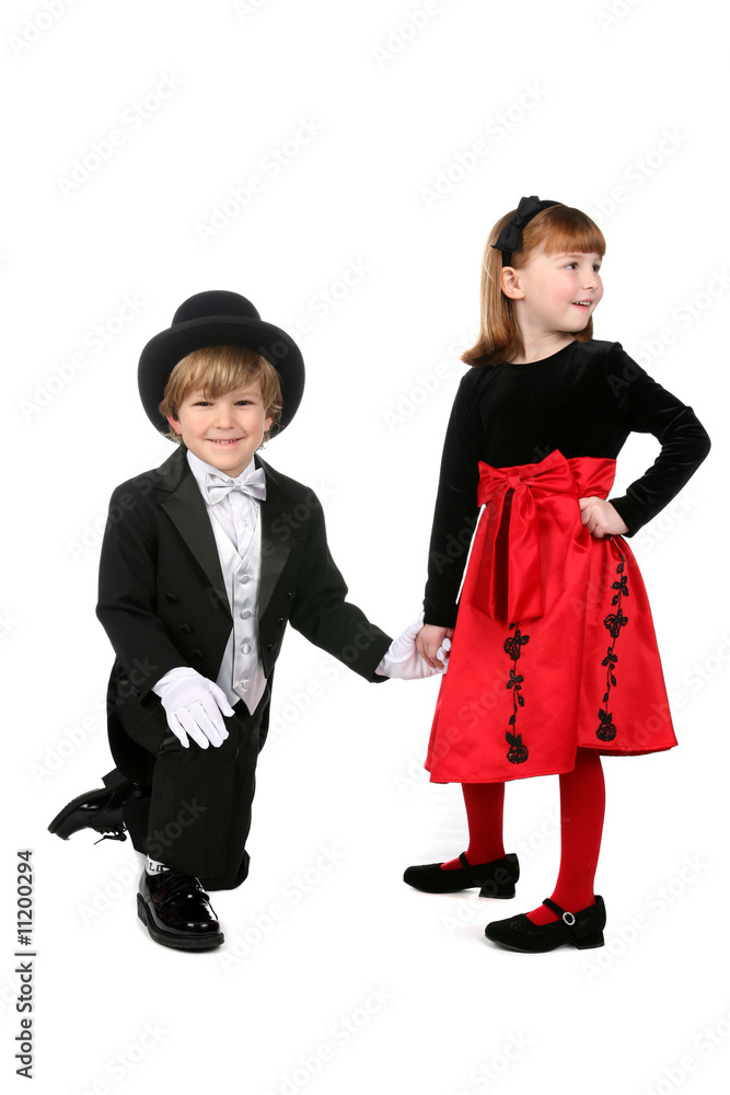 young boy in tuxedo kneeling and holding hand of little girl young boy in tuxedo kneeling and holding hand of little girl