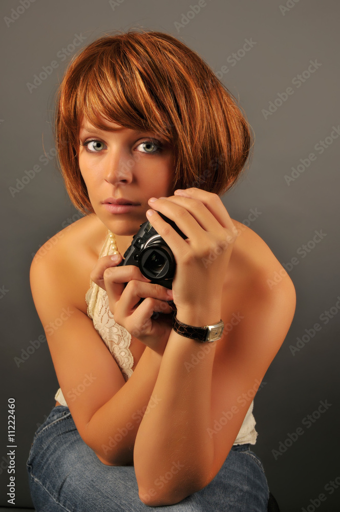 Beautiful woman with red hair holding camera. Beautiful woman with red hair holding camera.