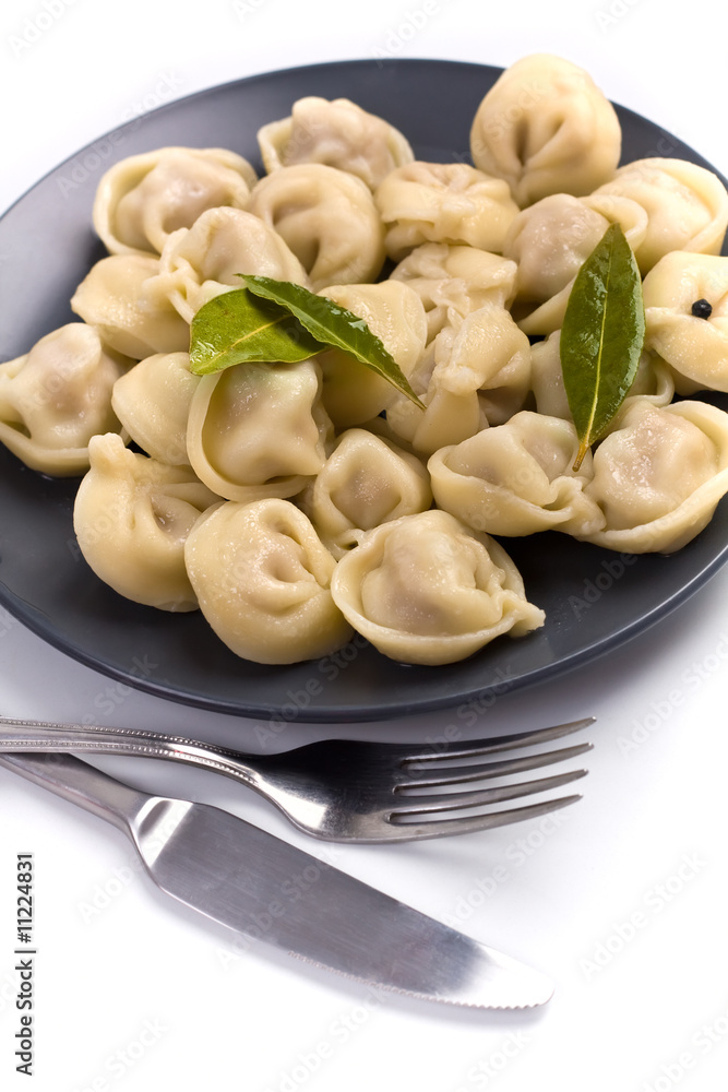 ravioli on a dark plate with fork and knife ravioli on a dark plate with fork and knife