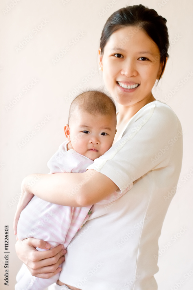 Smiling mother embracing baby. High key image. Smiling mother embracing baby. High key image.