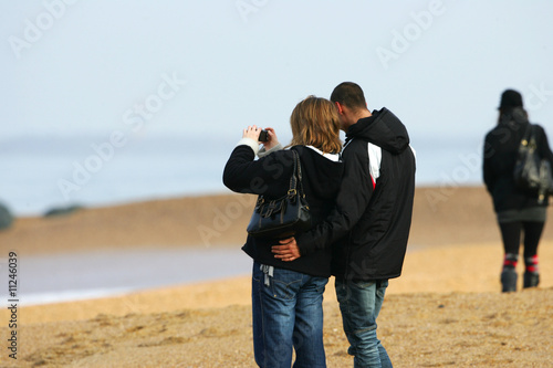 couple sur la plage en train de photographier