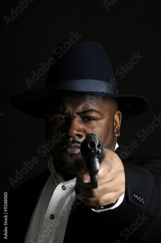 young African American man with gun pointed at camera