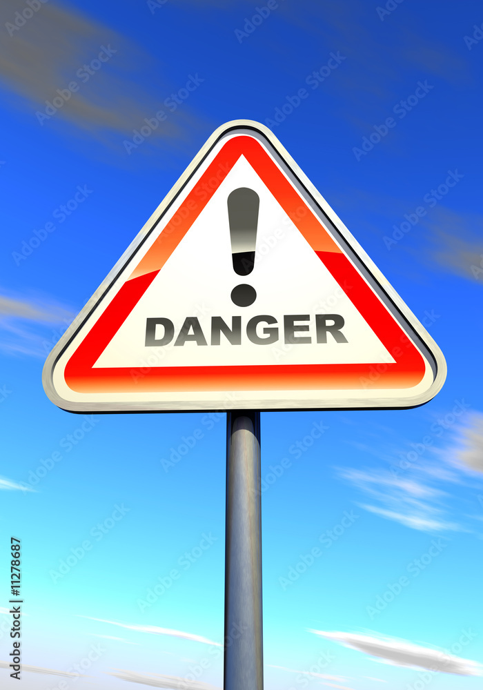 Danger - exclamation point sign against the cloudy sky Danger - exclamation point sign against the cloudy sky