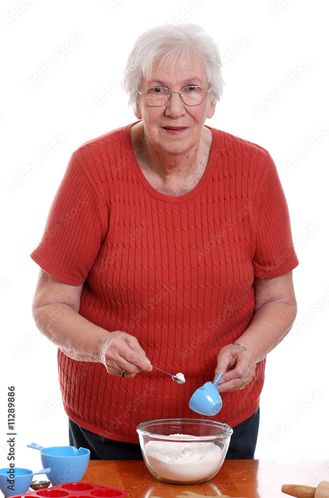 senior woman measuring while baking senior woman measuring while baking