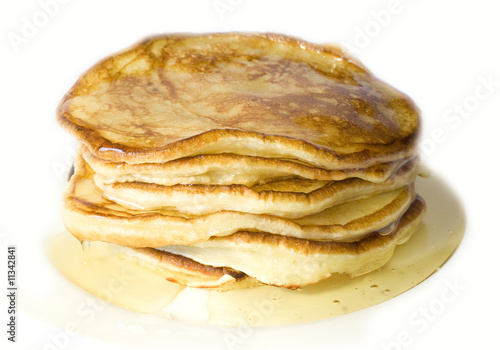 Pile of home-made pancakes with honey on white background