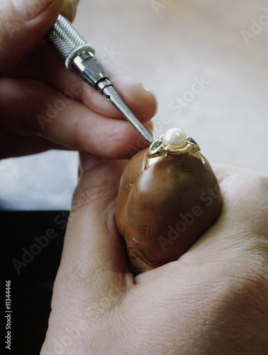 Foto mains du joaillier sur une bague