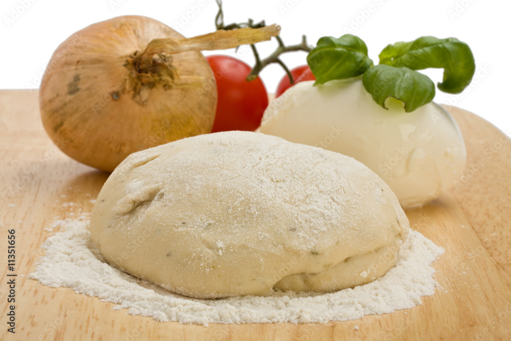 Hefeteig, Käse, Tomaten und Zwiebeln auf einem Holzbrett Hefeteig, Käse, Tomaten und Zwiebeln auf einem Holzbrett