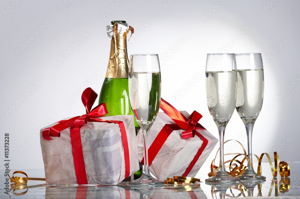 Glasses of champagne, gifts with red tapes and bows Glasses of champagne, gifts with red tapes and bows