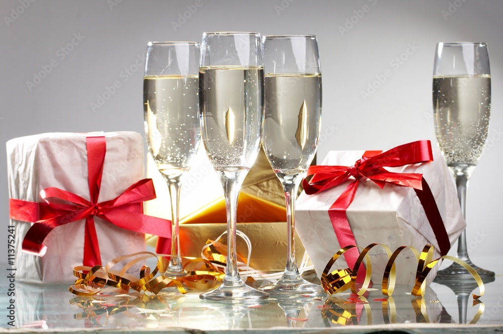 Glasses of champagne, gifts with red tapes and bows