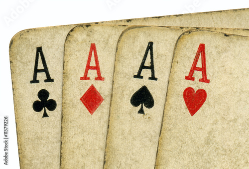 Close up of 4 old vintage dirty aces poker cards. photo