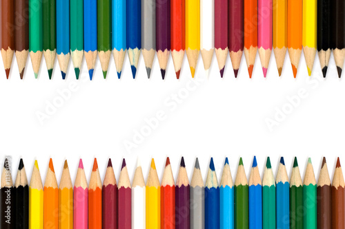 Top view of colored pencils frame arranged on white background.