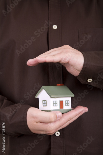 man holding a small house in his hands